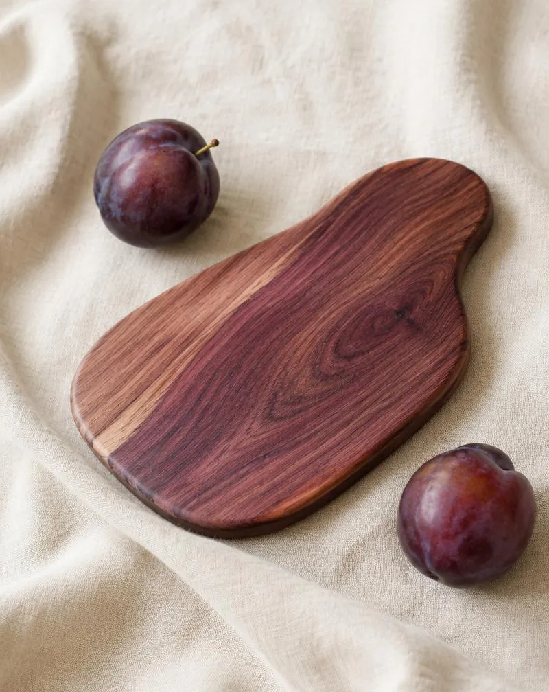 Small plum wood board with plum fruit